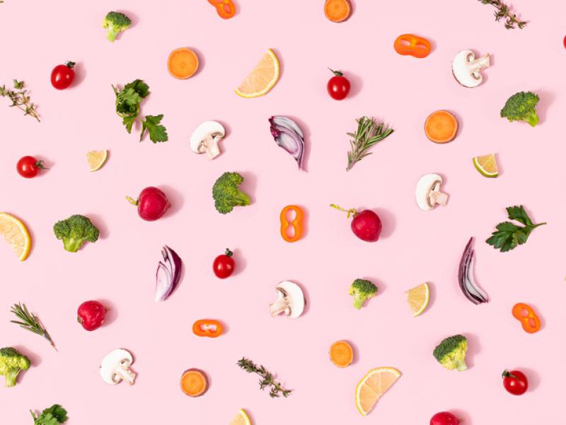 Pink wallpaper featuring healthy fruits and vegetables. 