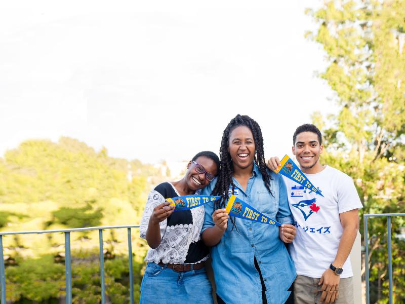 Three first generation college students posing with trees in background